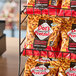 A rack of DOT'S HOMESTYLE PRETZELS packages on a table in a concession stand.