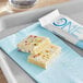 A white and yellow ONE Birthday Cake Protein Bar on a blue napkin.