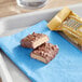 A chocolate covered FULFIL protein bar on a blue napkin.