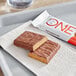 A ONE Peanut Butter Cup protein bar on a tray with a bite taken out of it.