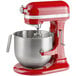 A red KitchenAid commercial mixer with a bowl attached.