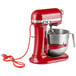 A red KitchenAid bowl lift mixer with standard accessories attached.