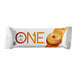 A white ONE protein bar package with orange text and a donut with frosting on top.