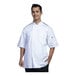 A man wearing a Uncommon Chef white short sleeve chef coat with black mesh back.