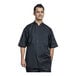 A man wearing a Uncommon Chef black chef coat with silver mesh and short sleeves.