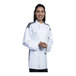 A woman in a white Uncommon Chef Solta chef coat with a black mesh back is smiling.