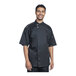A man wearing a Uncommon Chef black short sleeve chef coat with silver mesh back.