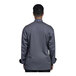 A man wearing a Uncommon Chef slate grey long sleeve chef coat with a mesh back.
