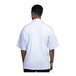 A man wearing a Uncommon Chef white short sleeve chef coat with white mesh back.