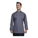 A man wearing a Uncommon Chef Solta grey long sleeve chef coat with a gray mesh back smiling.