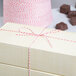 A close-up of a red and white Baker's Mark twine tied box.