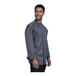 A man wearing a Uncommon Chef slate grey long sleeve chef coat with mesh back.