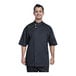 A man wearing a black Uncommon Chef Bari short sleeve chef coat with black mesh back.