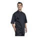 A man wearing a black Uncommon Chef Bari short sleeve chef coat with black mesh back.