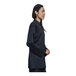 A woman wearing a Uncommon Chef black long sleeve chef coat with a black shirt underneath.