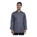 A man wearing a Uncommon Chef Turin long sleeve chef coat with a slate mesh back smiling in a professional kitchen.