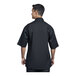 A man wearing a black Uncommon Chef Venice short sleeve chef coat with black mesh back.