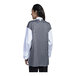 A woman wearing a white Uncommon Chef long sleeve chef coat with a black and grey mesh back.