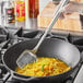 A person stirring noodles in a wok with a Town medium stainless steel wok spatula.