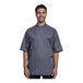 A man wearing a Uncommon Chef Modena slate short sleeve chef coat with gray mesh back.