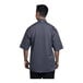 A man wearing a Uncommon Chef slate grey short sleeve chef coat with a slate mesh back.