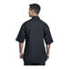 A man wearing a black Uncommon Chef Venice short sleeve chef coat with black mesh back.