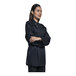 A woman wearing a black Uncommon Chef long sleeve chef coat.