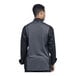 The back of a man wearing a black and grey Uncommon Chef Genoa chef coat with silver mesh.
