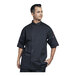 A man wearing a black Uncommon Chef Luca chef coat with black mesh details.