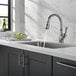 A Delta Leland kitchen faucet with a lever handle running water over a bowl in a sink.