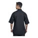 A man wearing a black Uncommon Chef Venice chef coat with black mesh on the back.