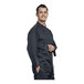 A man in a black Uncommon Chef Treviso 3/4 sleeve chef coat with black mesh back.