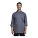 A man wearing a Uncommon Chef long sleeve chef coat with a gray mesh back.