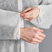 A person wearing a Lavex white polypropylene lab coat and gloves.