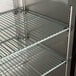 An Avantco metal shelf for the back bar of a refrigerator.