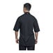 A man wearing a Uncommon Chef black short sleeve chef coat with black mesh back.