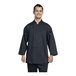 A man wearing a black Uncommon Chef split 3/4 sleeve chef coat with a silver mesh back is smiling.