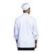 A man wearing a Uncommon Chef white long sleeve chef coat with white mesh back.