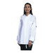 A woman wearing a white Uncommon Chef long sleeve chef coat with white half mesh back.