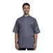 A man wearing an Uncommon Chef short sleeve chef coat with a gray mesh back.