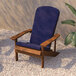 A blue Flash Furniture Charlestown Adirondack chair with a blue cushion on a gravel surface.