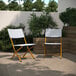 Two Flash Furniture folding chairs with navy and white synthetic rattan on a patio.