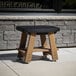 A black Mayne Mesa side table with wooden legs on an outdoor patio.