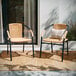 Two Flash Furniture Lila beige rattan arm chairs on a patio.