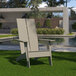 A Flash Furniture Sawyer Gray Faux Wood Adirondack chair sitting on the grass.