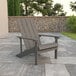 A Flash Furniture gray faux wood Adirondack chair on a stone patio.