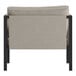 The back of a Flash Furniture Lea black steel frame arm chair with beige cushions and storage pockets.