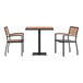 A Flash Furniture outdoor table with a black base and natural faux teak slat top with two stackable arm chairs.