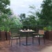 A Flash Furniture natural faux teak slat table with two chairs on a wooden deck.