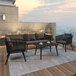 Black patio furniture including a couch, chairs, and a coffee table on an outdoor patio.